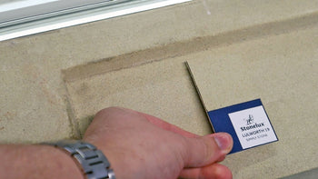 Stonelux colour swatch in Lulworth 19 being held against a stone windowsill for colour matching.