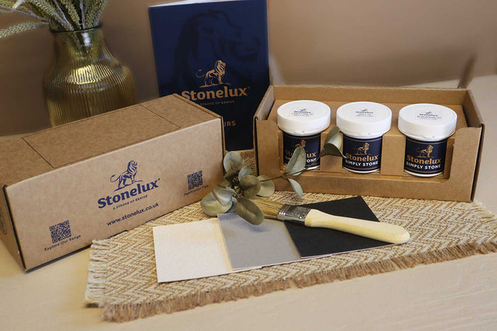 Stonelux sample pots sitting on a table with 2 natural bristled brushes