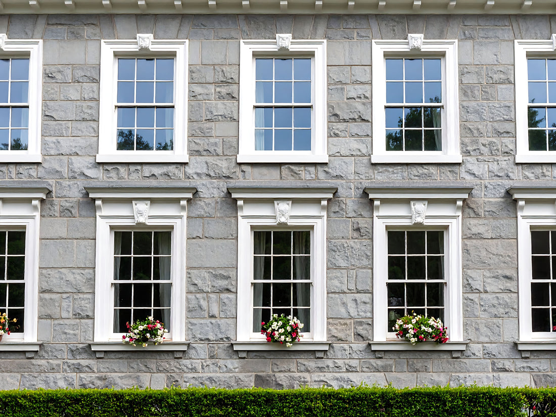 Dover 70 Windowsill Paint applied to exterior window surrounds on a grey stone building with a cool off-white stone finish