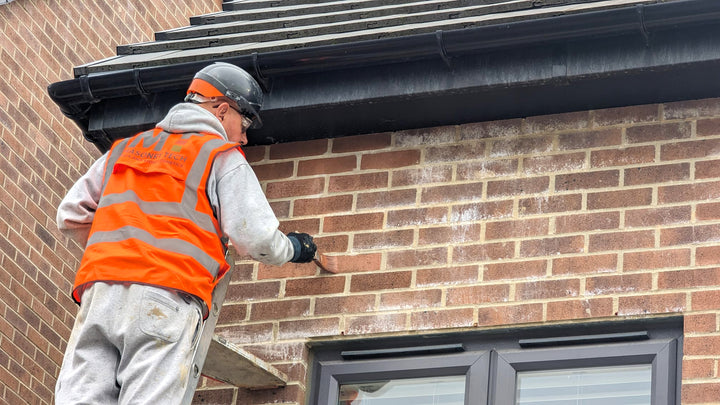 a tradesperson applying stonelux brick tint to a house