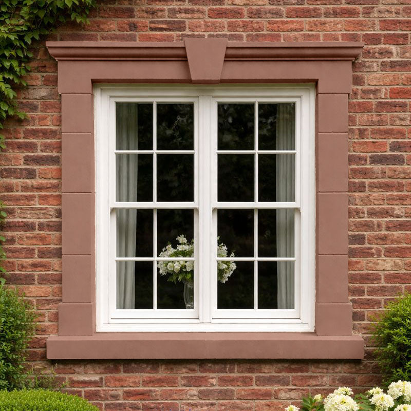 Millgate 37 Stonelux stone effect paint colour inspiration on an exterior window surround against red brick with a warm rose brown sandstone finish with muted pink and terracotta tones